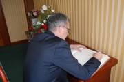 Ambasador Węgier wpisuje się do księgi pamiątkowej.