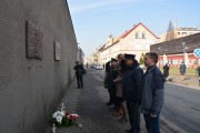 Delegacja składa kwiaty pod tablicą ofiar okresu stalinowskiego.