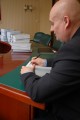 Wojewoda przy biurku z dokumentami w tle na budowę Gazociągu Lwówek-Odolanów. 