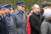 Dyrektor generalny WUW Jacek Woźniak i komendanci policji stoją przy pomniku.