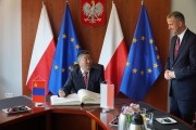 Ambasador wpisuje się do księgi pamiątkowej Wielkopolskiego Urzędu Wojewódzkiego