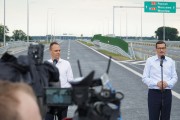 Premier oraz wiceminister infrastruktury przemawiają na tle drogi