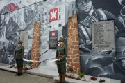 uczniowie w mundurach z okresu powstania wielkopolskiego przed muralem 