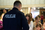 Policjant prezentuje dzieciom stoisko edukacyjne