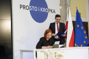Przedstawicielka Wielkopolskiego Urzędu Wojewódzkiego siedzi przy stole i podpisuje deklarację