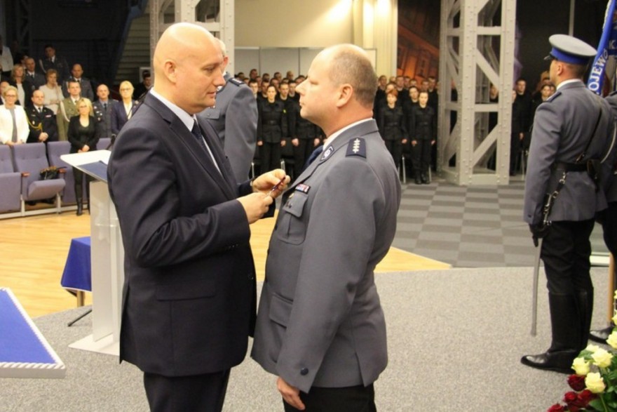 Wojewoda wielkopolski przypina odznaczenie policjantowi.
