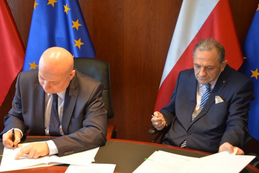 Wojewoda i starosta podpisują kopie umów.