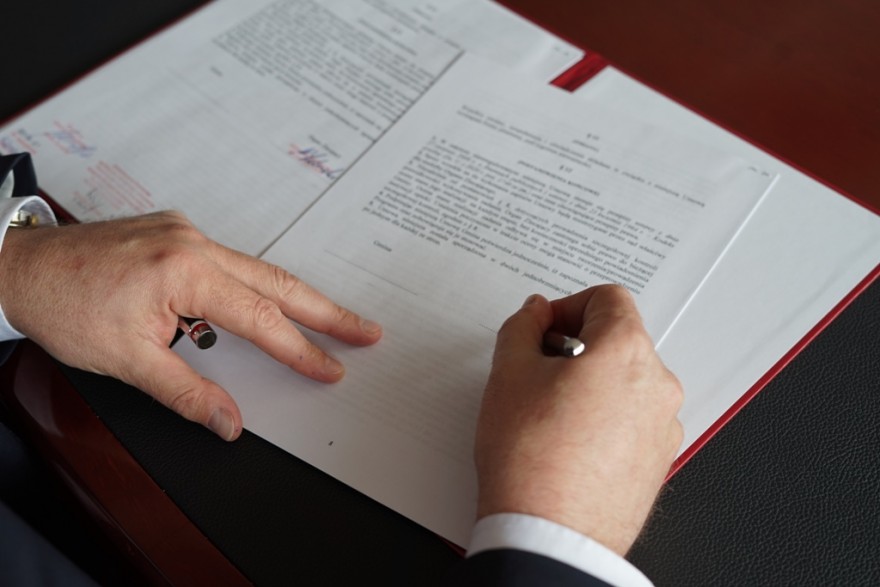 Zdjęcie przedstawia dłonie wojewody podpisującego dokument