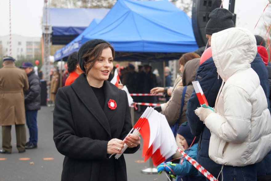 wojewoda rozdaje flagi uczestnikom obchodów Święta Niepodległości