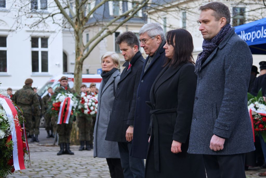 wspólne składanie kwiatów przy pomniku przez władze rządowe i samorządowe