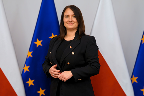 I wicewojewoda wielkopolska Karolina Fabiś-Szulc, w tle flagi polska i UE